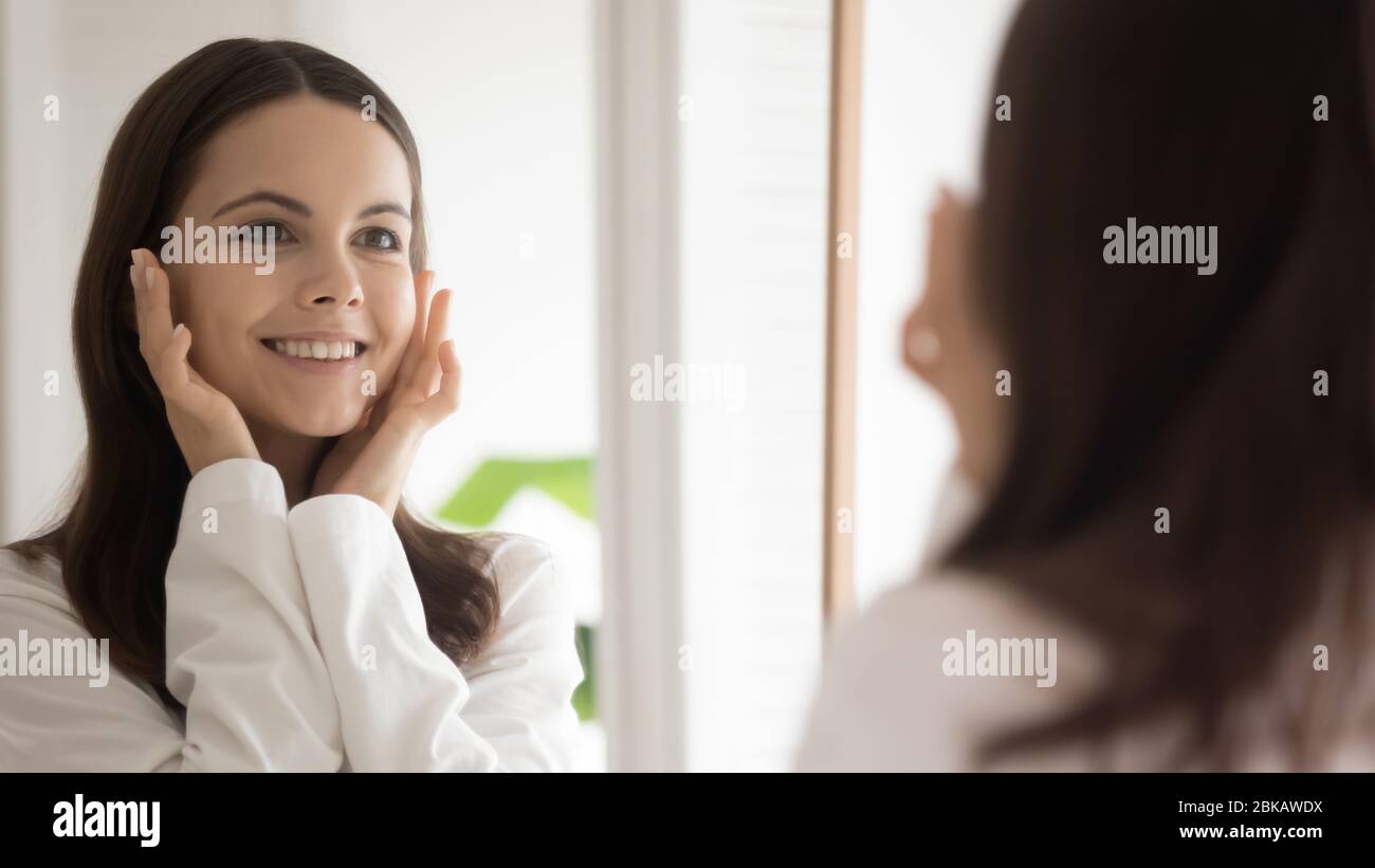 Young woman look in mirror do facial procedures Stock Photo - Alamy