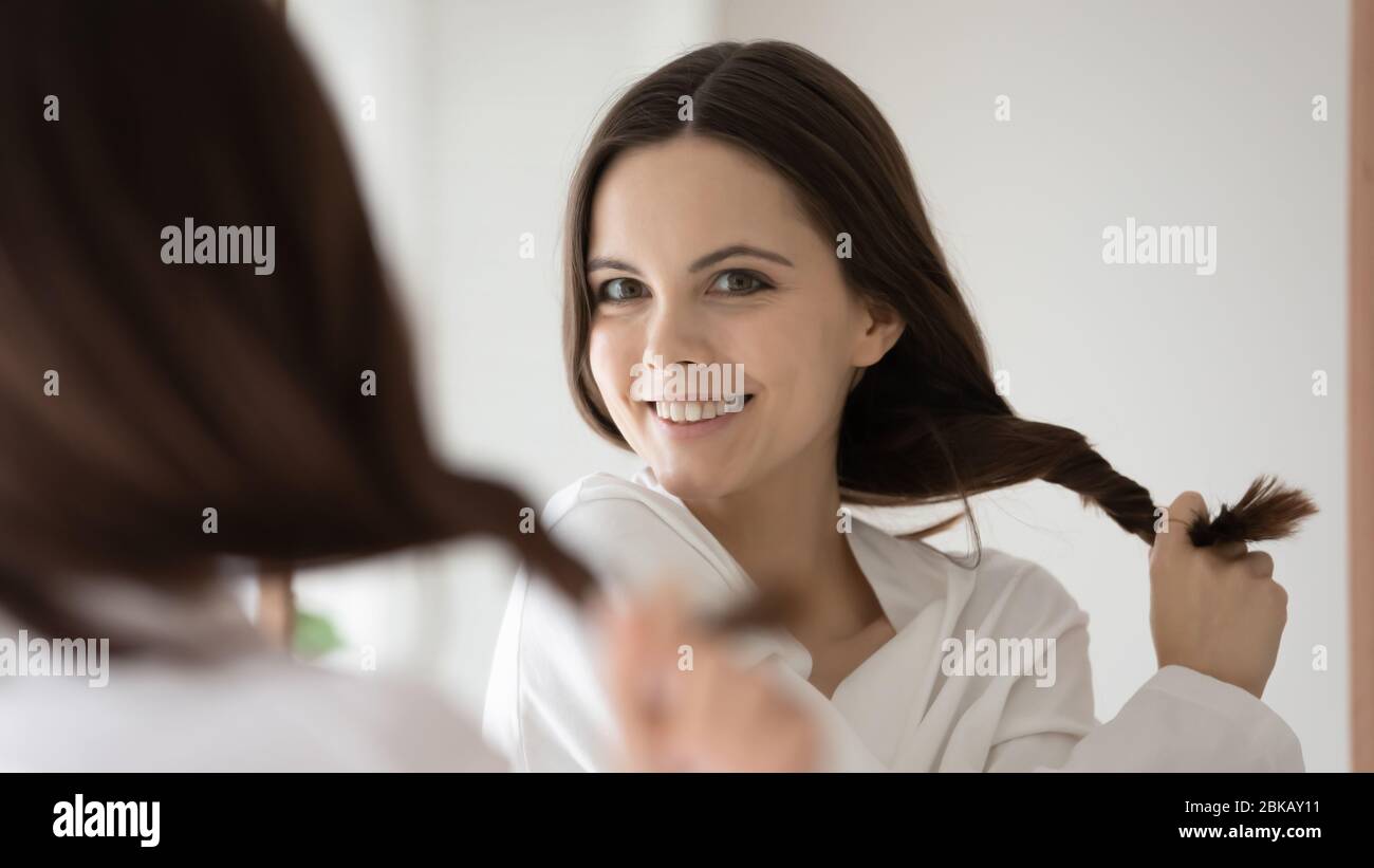 Young woman look in mirror show thick healthy hair Stock Photo Alamy