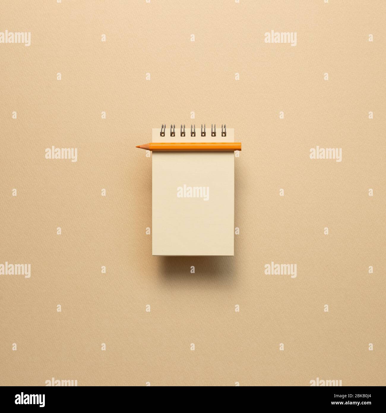 Empty kraft notepad with colored pencil on beige background. top view, copy space Stock Photo
