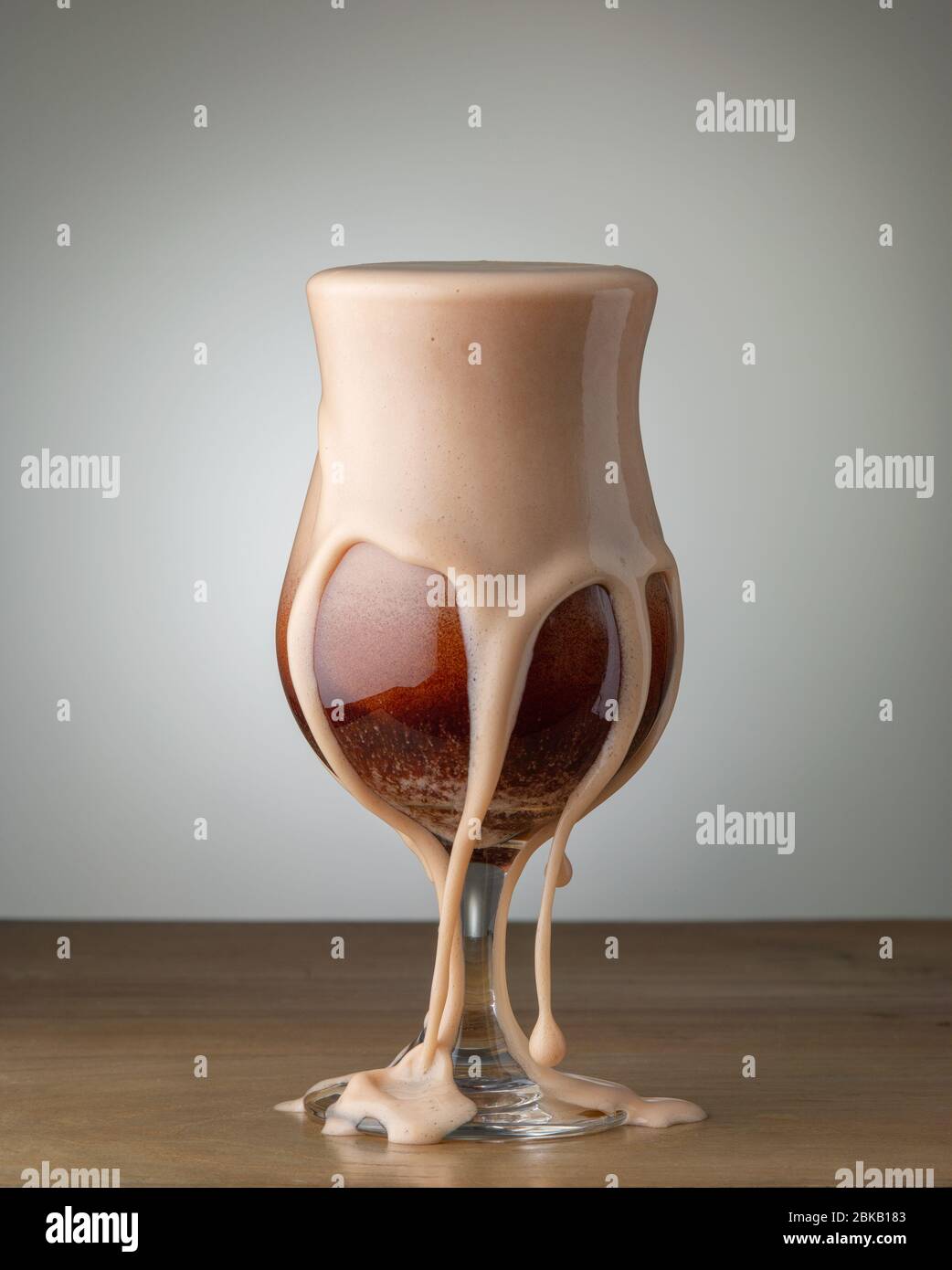 glass of beer cocktail with foam splashes on wood bar table Stock Photo