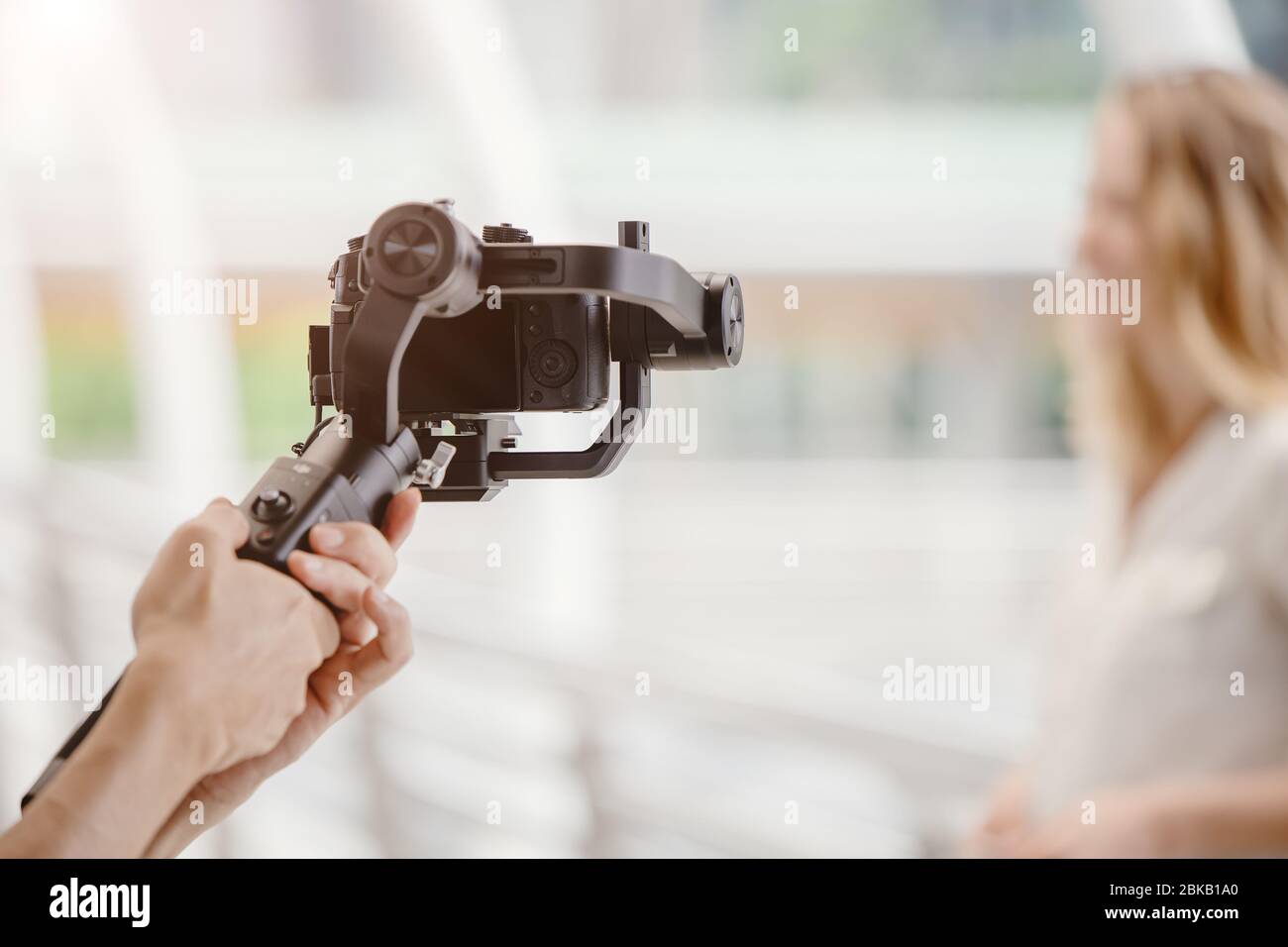 motorized gimbal, videographer using dslr camera anti shake tool for stabilizer record video scene. Stock Photo