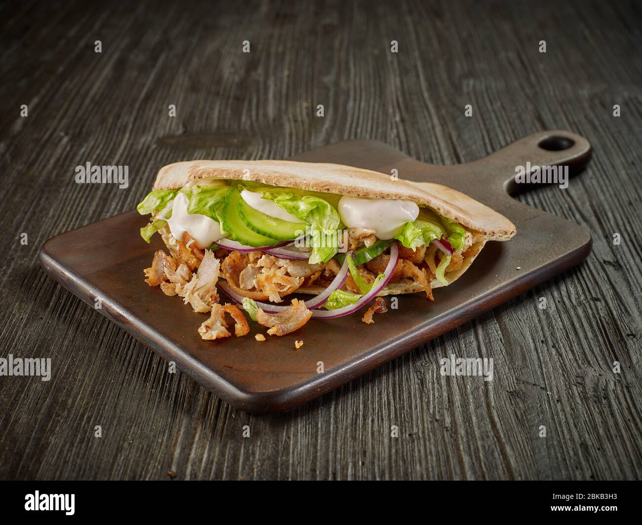 doner kebab on dark wooden kitchen table Stock Photo - Alamy