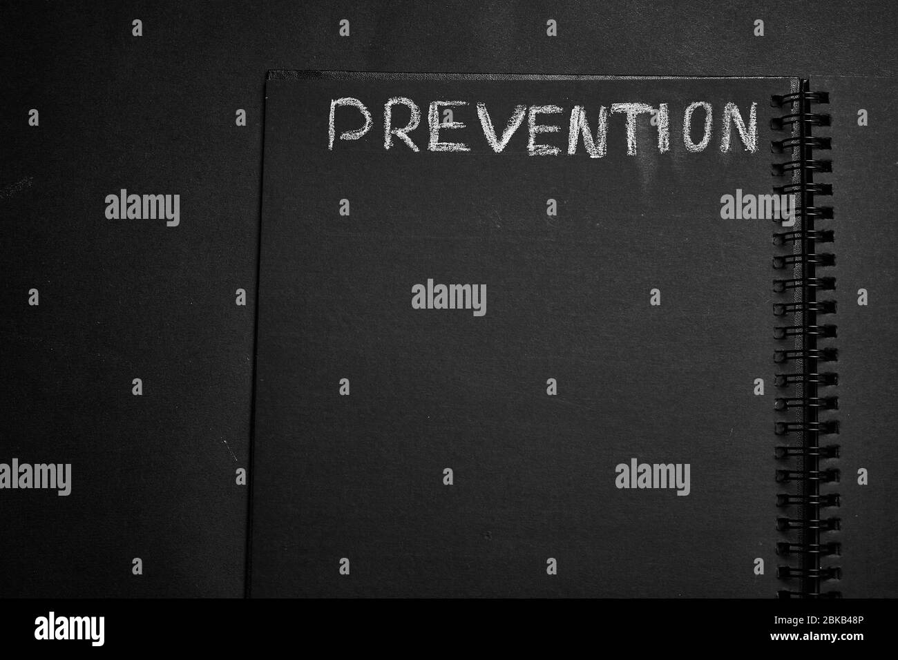 Prevention word written on a notepad with blank space. Blank black notepad background. Stock Photo