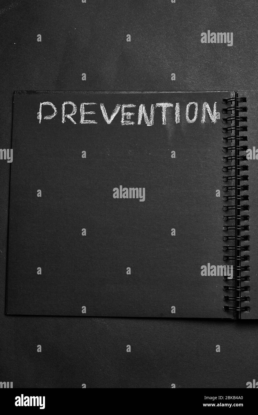 Prevention word written on a notepad with blank space. Blank black notepad background. Stock Photo