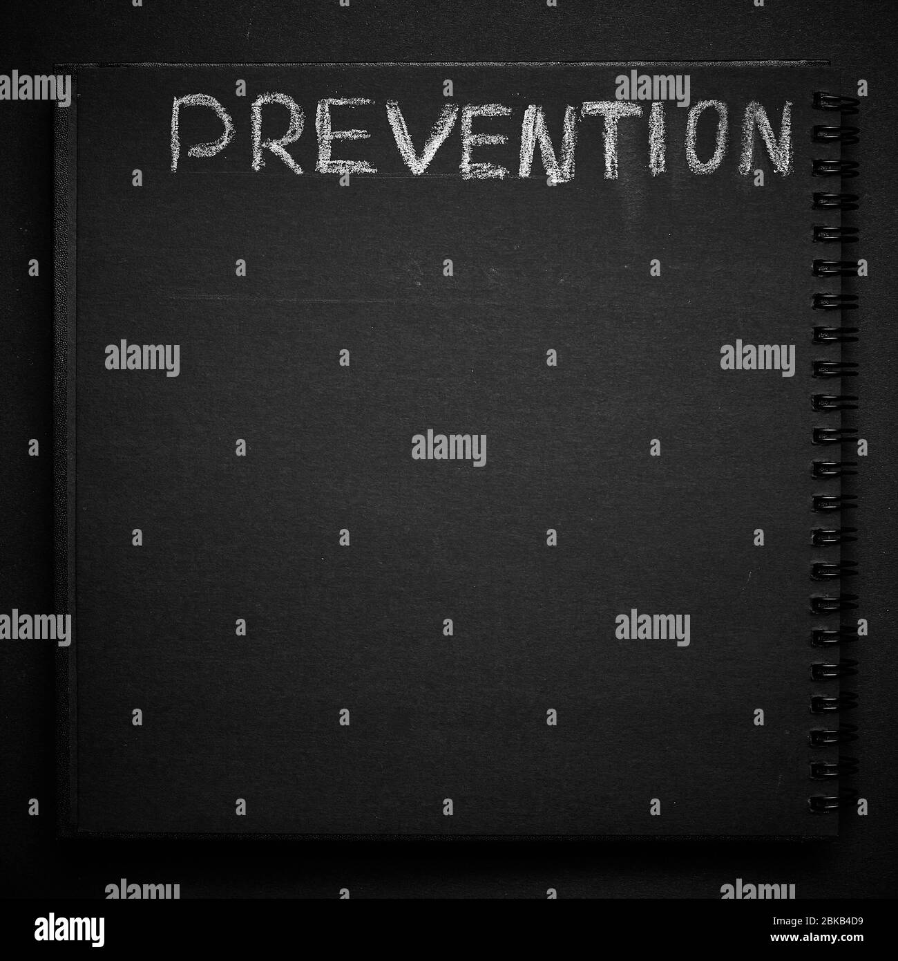 Prevention word written on a notepad with blank space. Blank black notepad background. Stock Photo