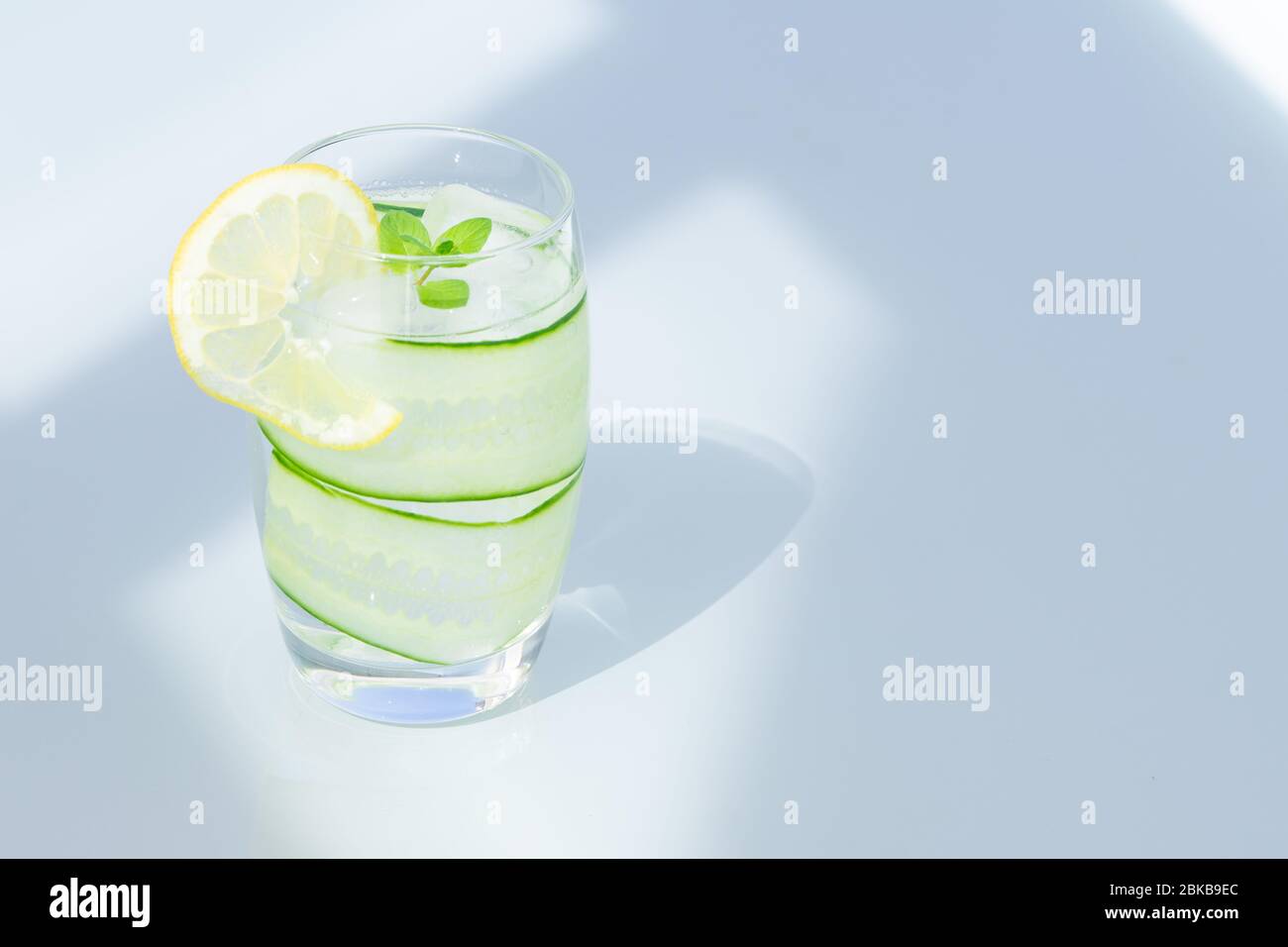 Glass of water with lemon, ice, and cucumber isolated. copy space.  Stock Photo