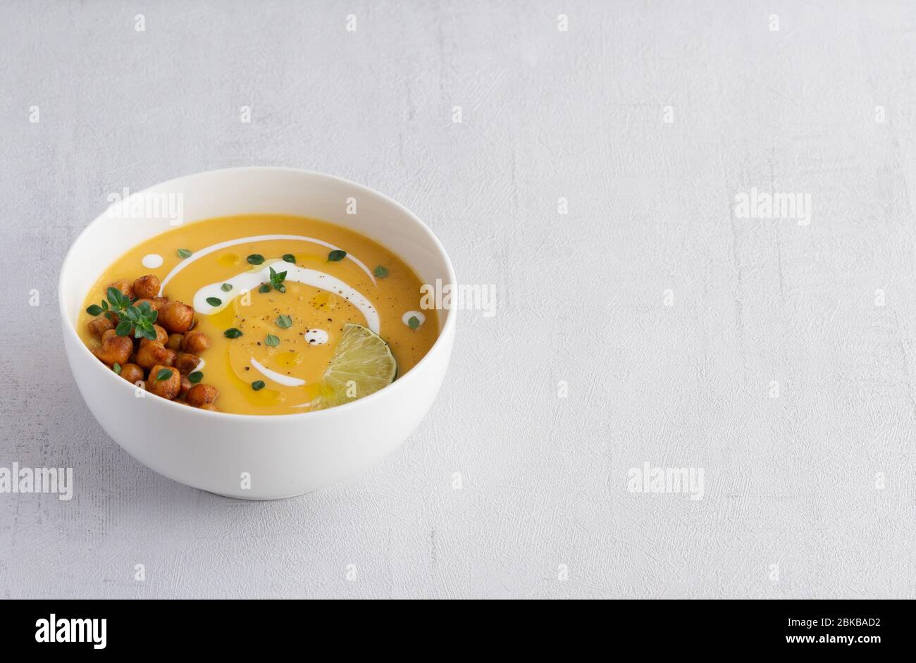 Pumpkin vegetarian cream soup isolated on grey background. Copy space. Stock Photo
