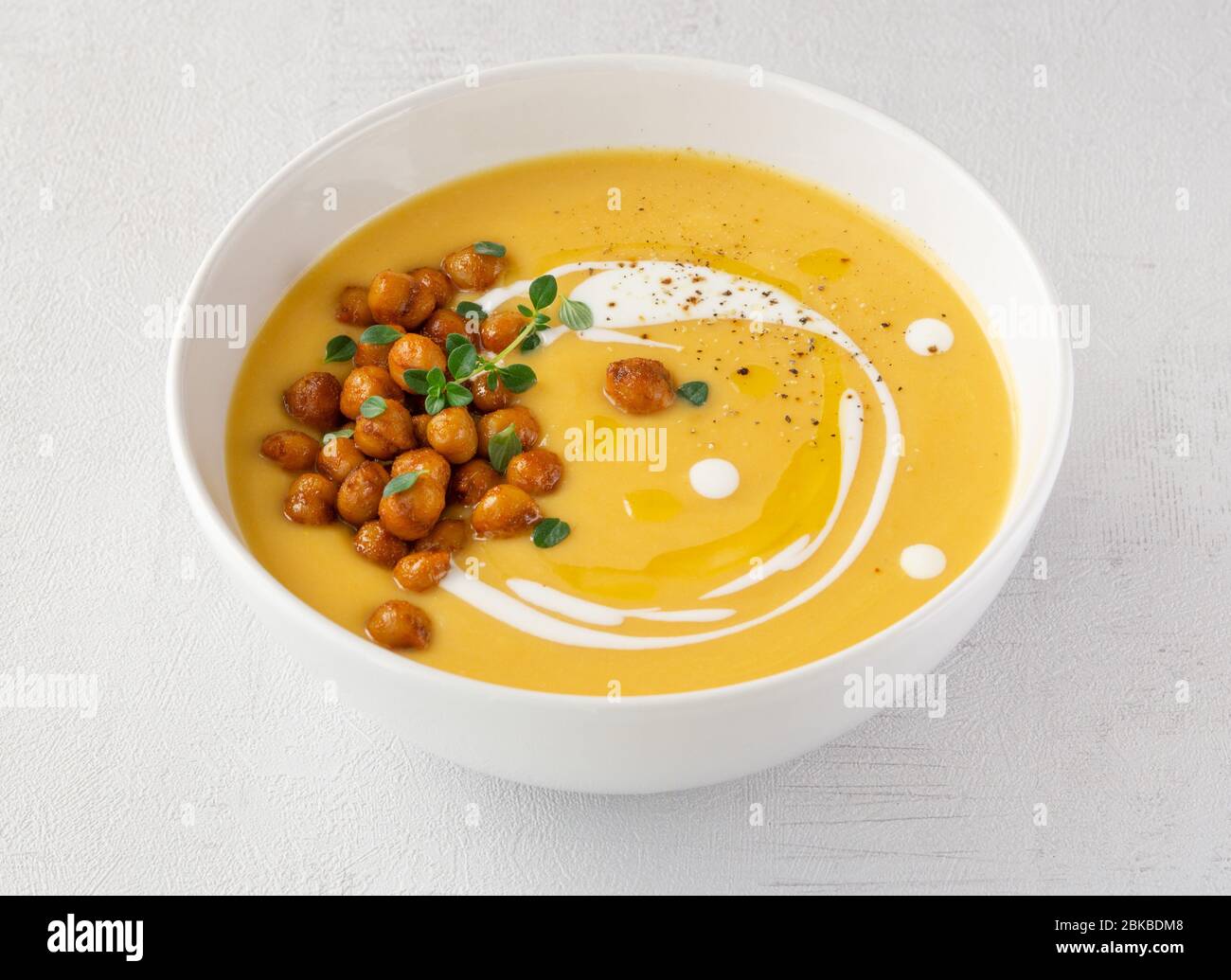 Pumpkin cream soup with spicy chickpeas. Close up. Isolated.  Stock Photo