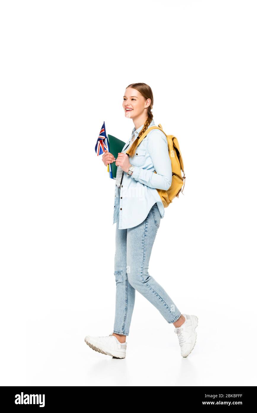 smiling girl with braid and backpack walking with flag of united kingdom and copybooks isolated on white Stock Photo