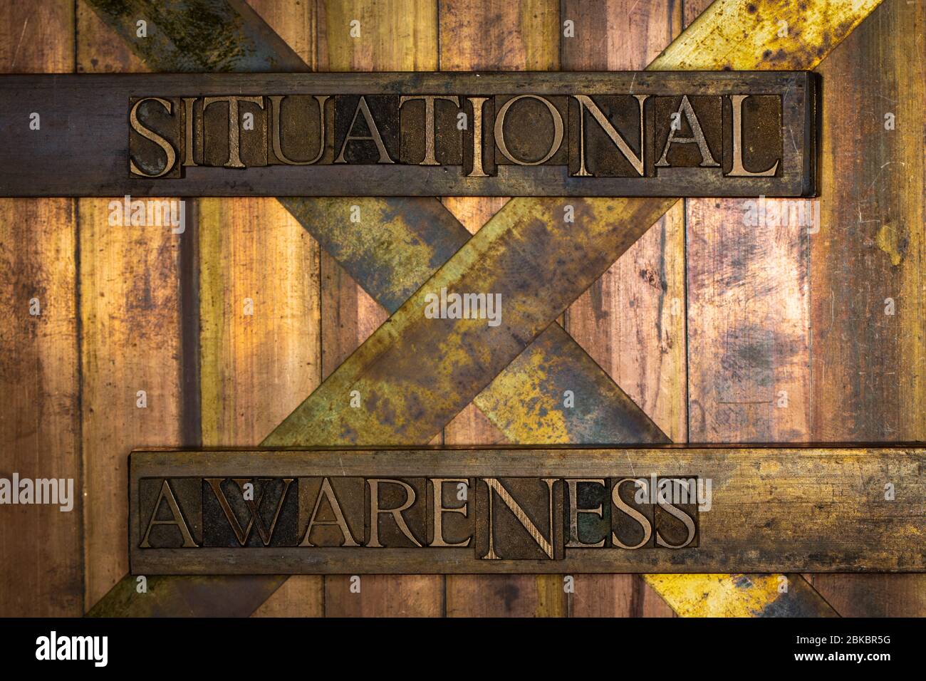 Photo of real authentic typeset letters Situational Awareness text on vintage textured grunge copper and gold background Stock Photo