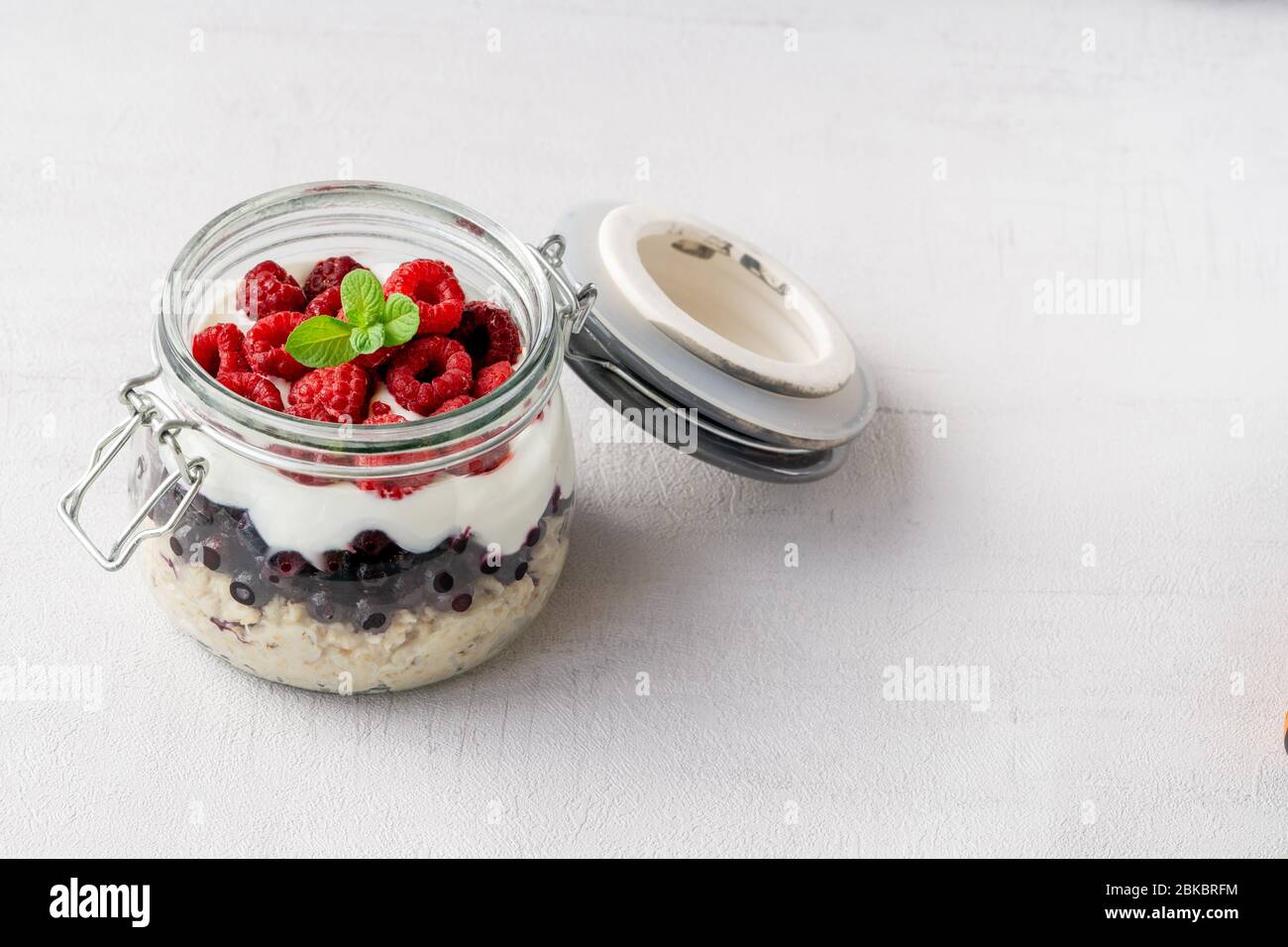 Overnight oatmeal with raspberries. Vegetarian breakfast. Copy space. Stock Photo