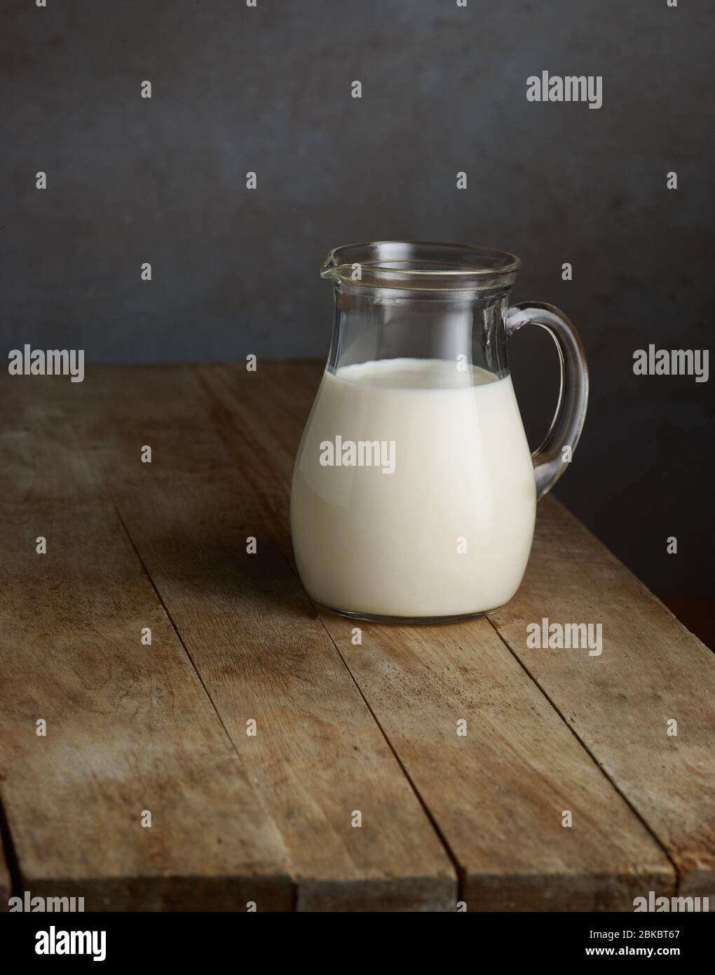 milk jug on old wooden kitchen table Stock Photo