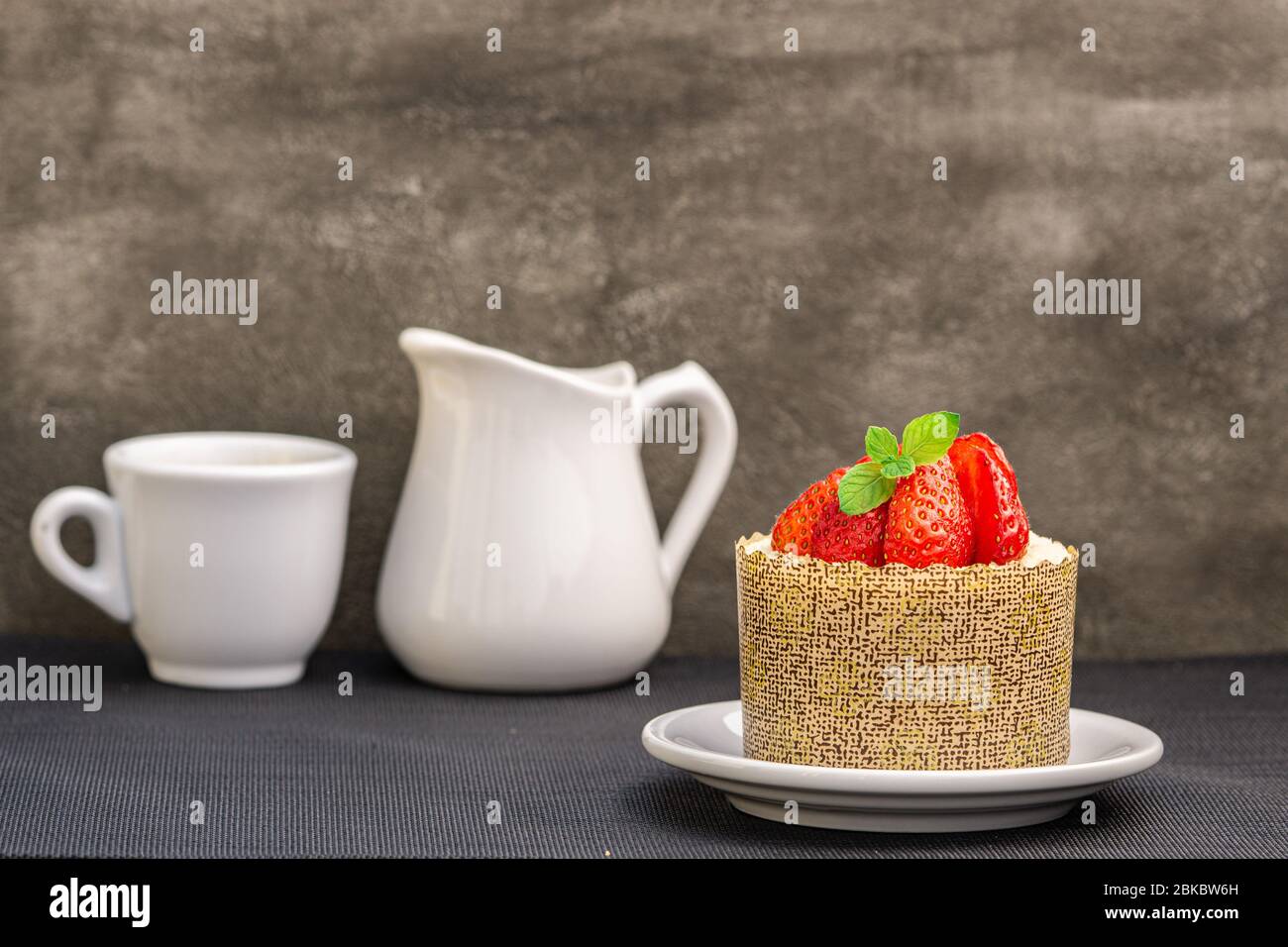 Cake with strawberries and cup of espresso coffee. Copy space. Stock Photo