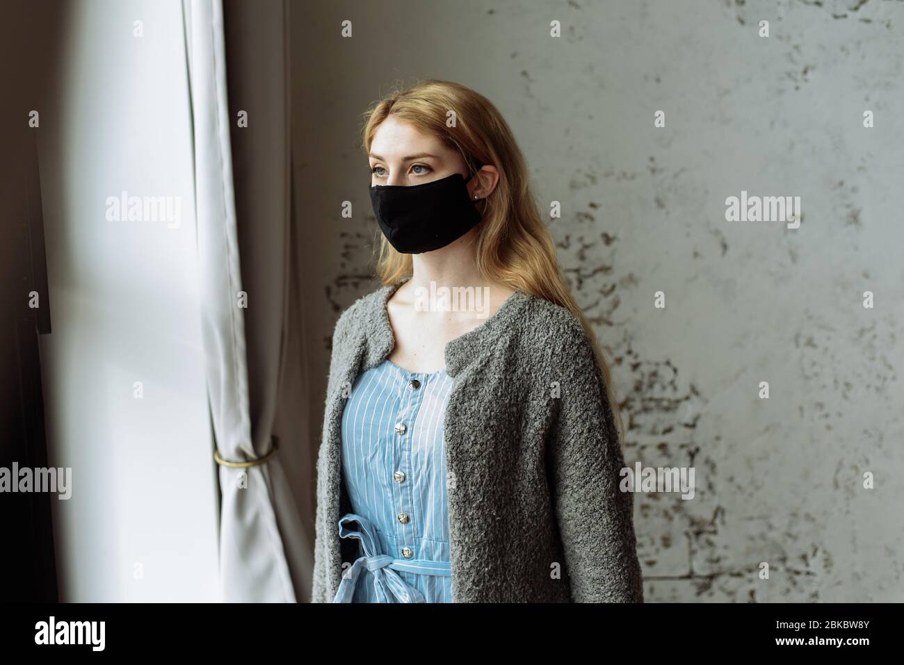 Young woman in medical mask stay isolation at home for self quarantine. Concept home quarantine, prevention COVID-19, Coronavirus outbreak situation. Stock Photo