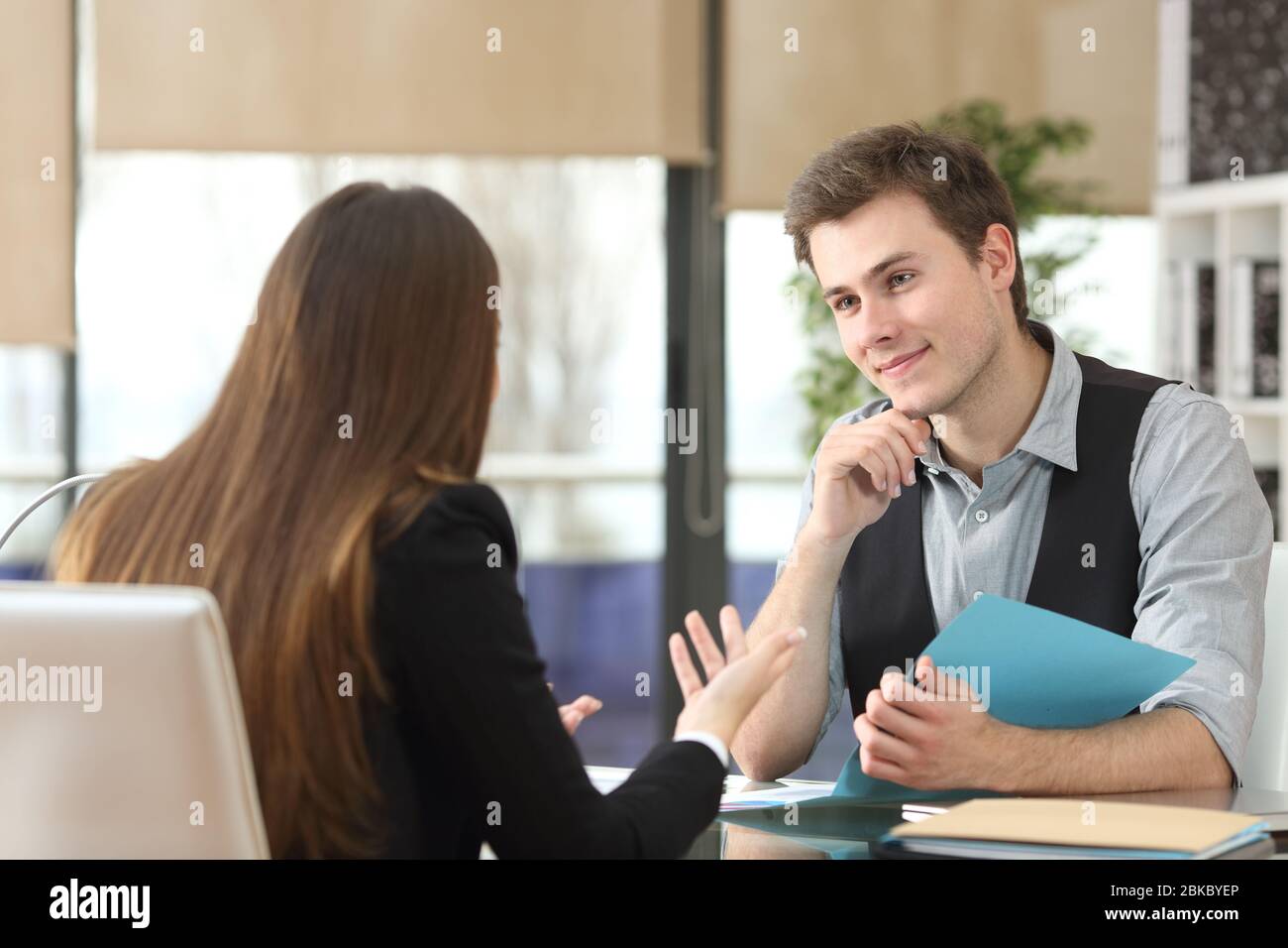 Satisfied businesspeople talking during an interview sitting at office Stock Photo