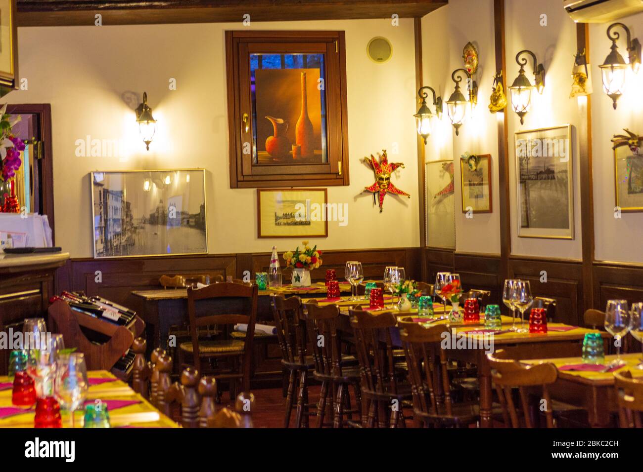 Interior of traditional Italian restaurant with tables loaded with
