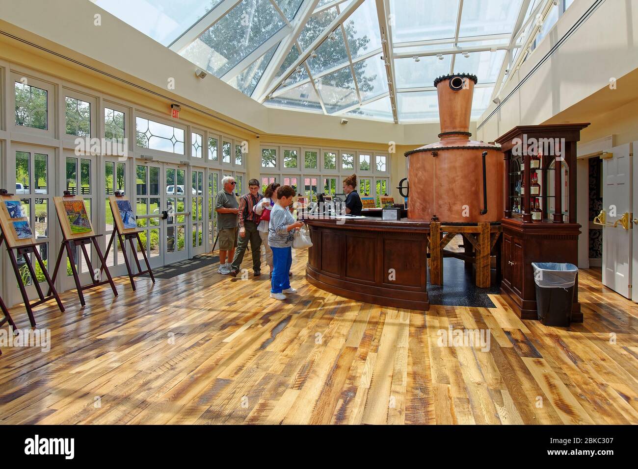 Maker's Mark Bourbon Distillery; Visitor Center, glass roof, copper tank decoration, wood floor, paintings on easels, National Historic Landmark, peop Stock Photo