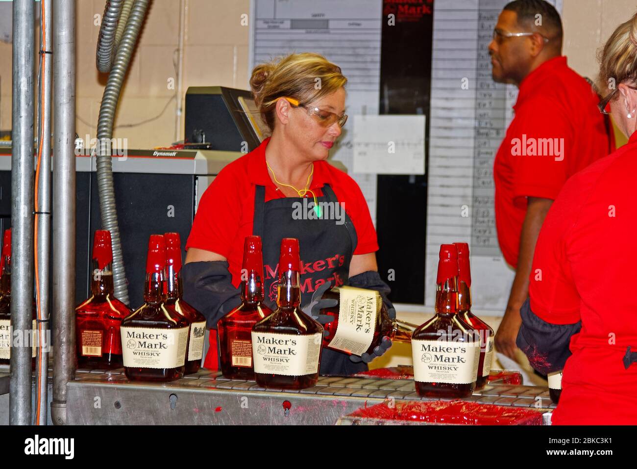 workers hand dipping bottles in red wax, traditional sealing, assembly line, movement, job, business, Maker's Mark Bourbon Distillery; National Histor Stock Photo