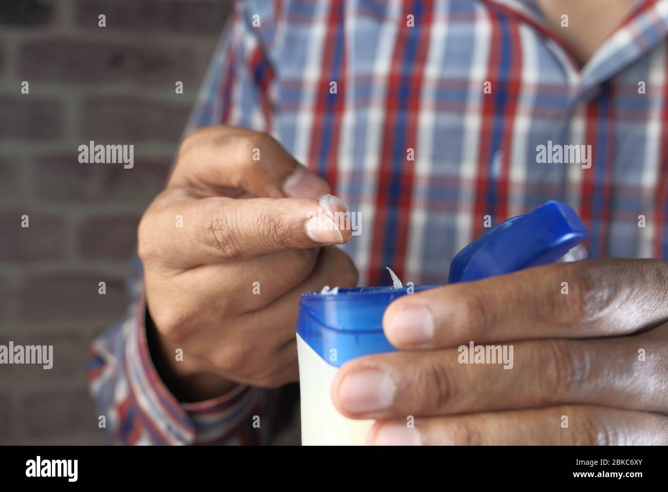 Man use white petroleum jelly, Close up  Stock Photo