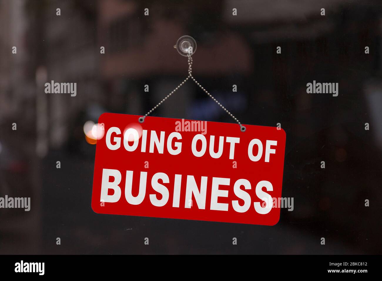 Close-up on a red closed sign in the window of a shop displaying the message 'Going out of business'. Stock Photo