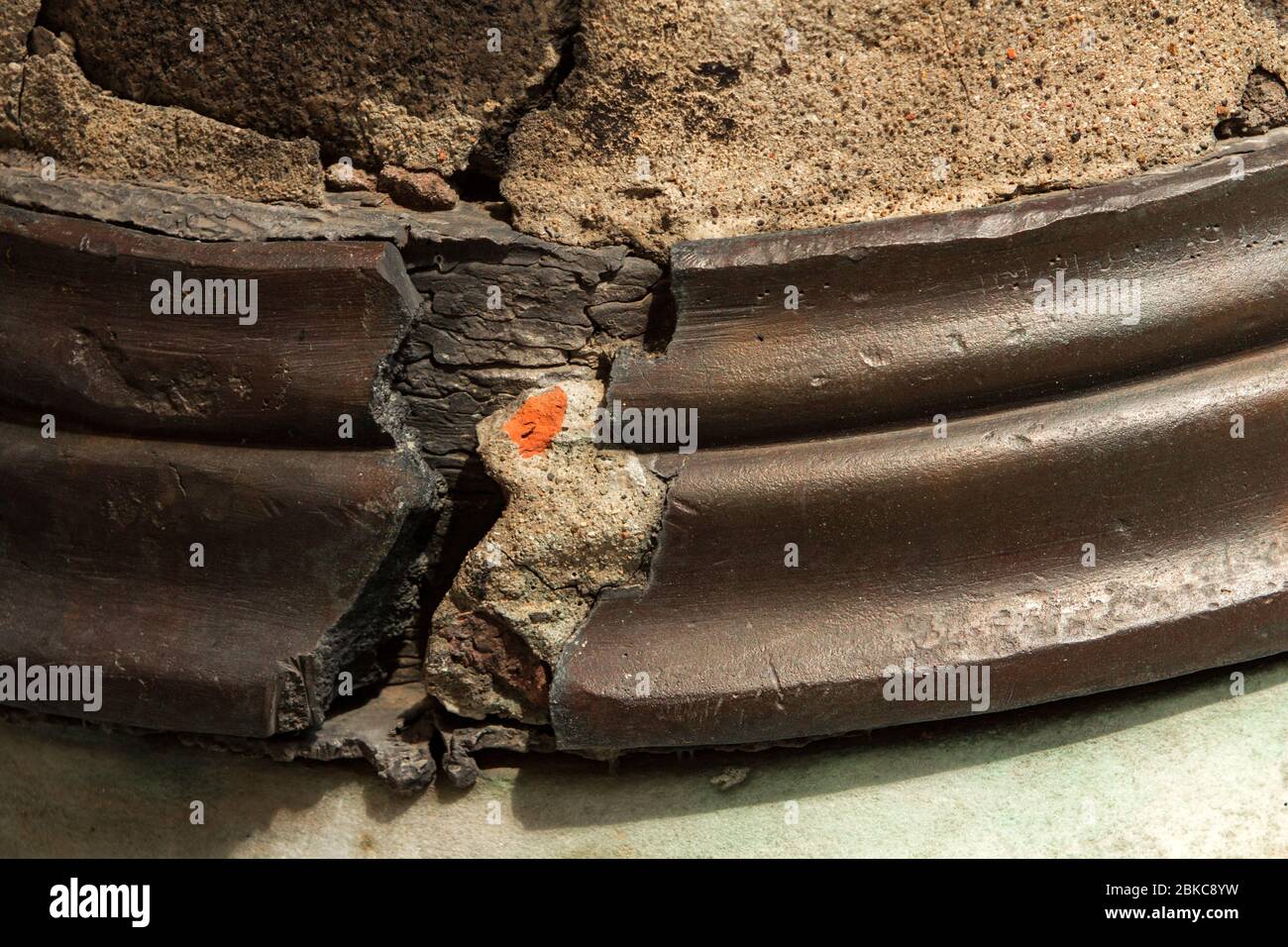 Close up of A cracked element used to repair the base of a column, with cement and brick pieces revealed. Stock Photo