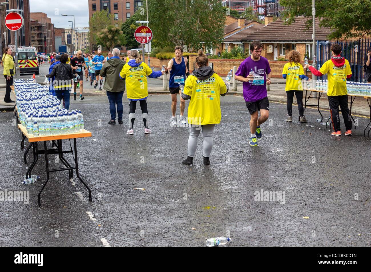 Volunteers handing out drinks at a water station on the 2019 Rock n roll Liverpool marathon, Nelson Street, Liverpool. Stock Photo