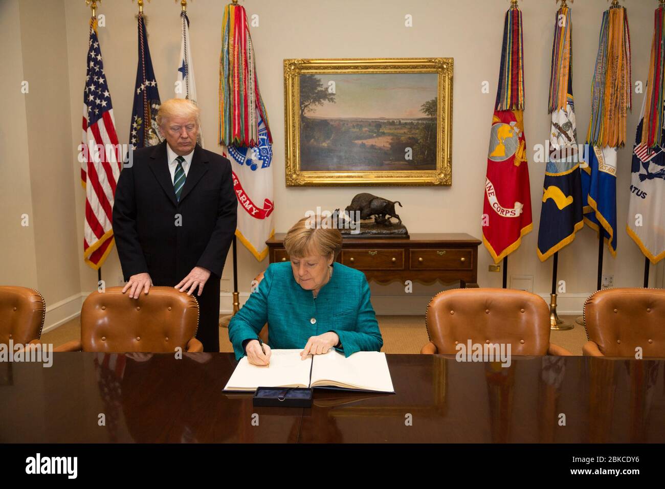 President Donald Trump accompanies German Chancellor Angela Merkel as she signs the guest book, Friday, March 17, 2017, in the Roosevelt Room, during her official visit to the White House in Washington, D.C. Foreign Leader Visits Stock Photo