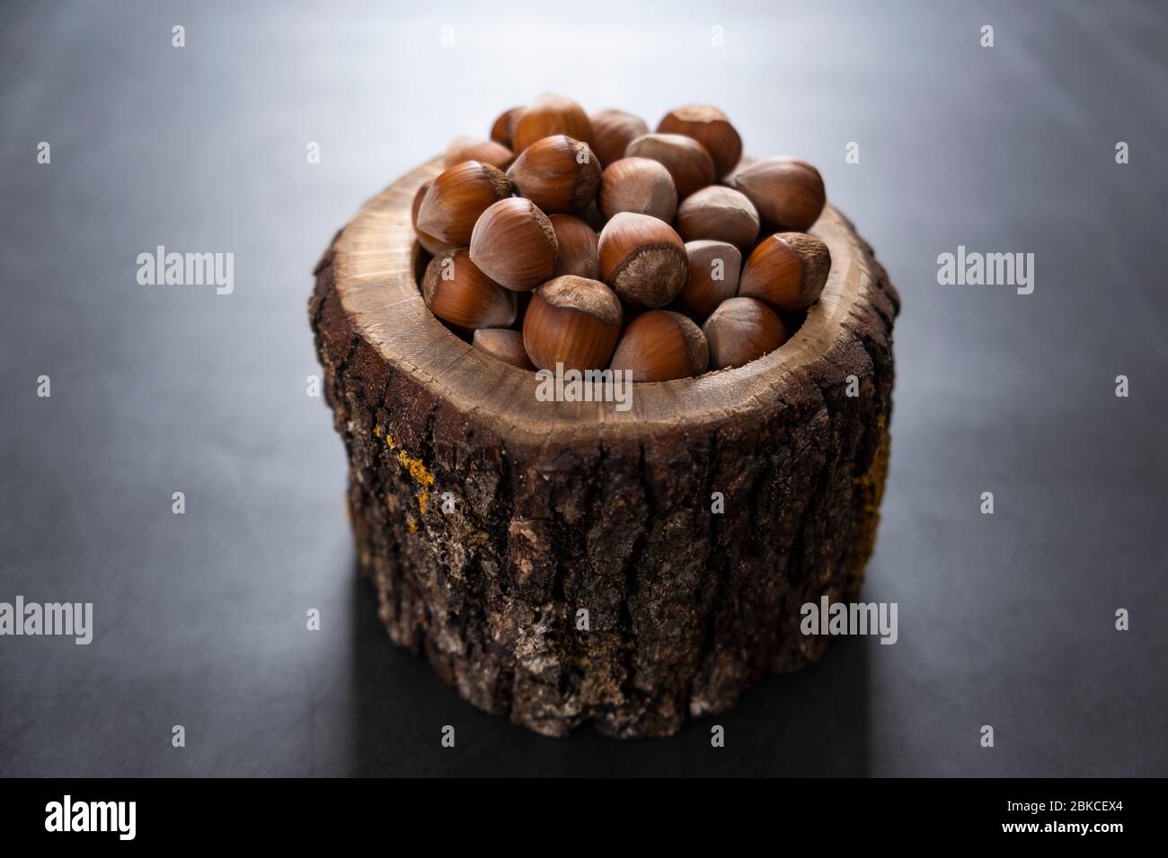Hazelnuts in wooden and rustic bowl. Raw and tasty nuts for snacks. Healthy, unroasted and delicious food. Stock Photo