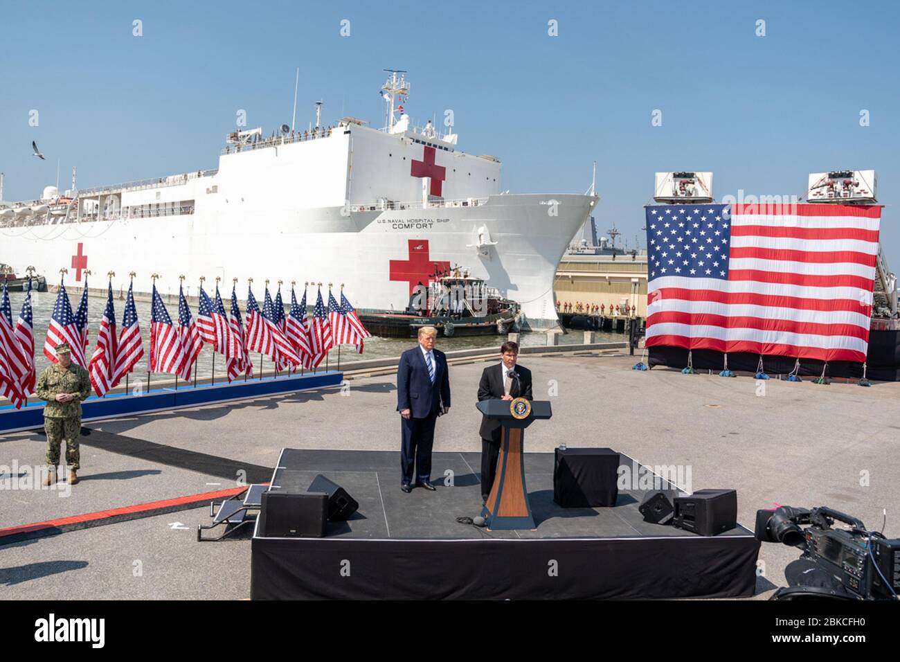 President Donald J. Trump listens as Secretary of Defense Mark Esper delivers remarks at Naval Air Station Norfolk Pier 8, Saturday, March 28, 2020, prior to the departure of the USNS Comfort, a U.S. Navy hospital ship stationed in Norfolk, Virginia. President Trump at the Send Off for the USNS Comfort Stock Photo