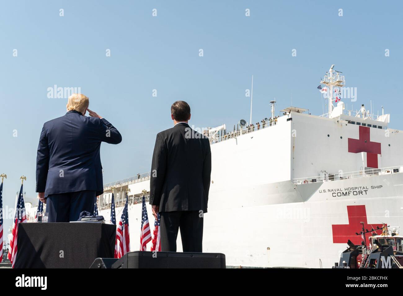 President Donald J. Trump, joined by Secretary of Defense Mark Esper, salutes the USNS Comfort Saturday, March 28, 2020, as she departs Naval Air Station Norfolk Pier 8 in Norfolk, Virginia en route to New York City. President Trump at the Send Off for the USNS Comfort Stock Photo