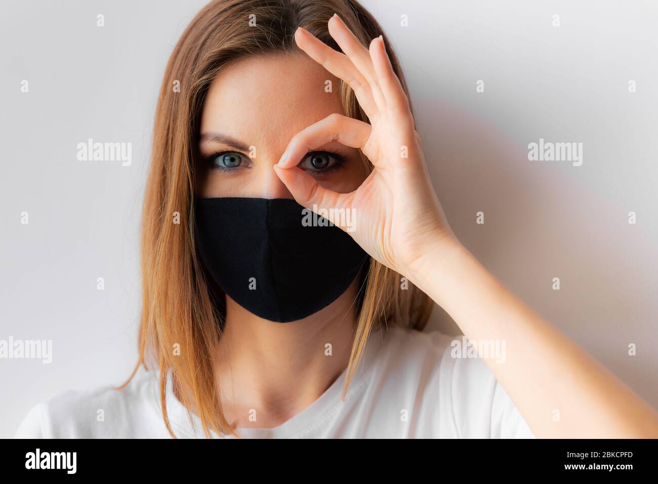 Beautiful close-up portrait of a young woman in a black medical mask ...