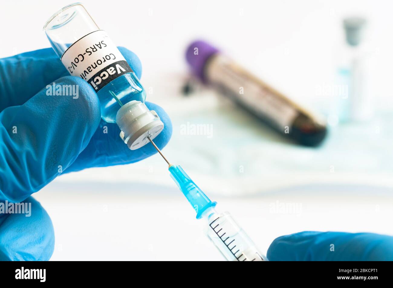 Coronavirus COVID-19 vaccine vial and injection syringe in medic hands ...