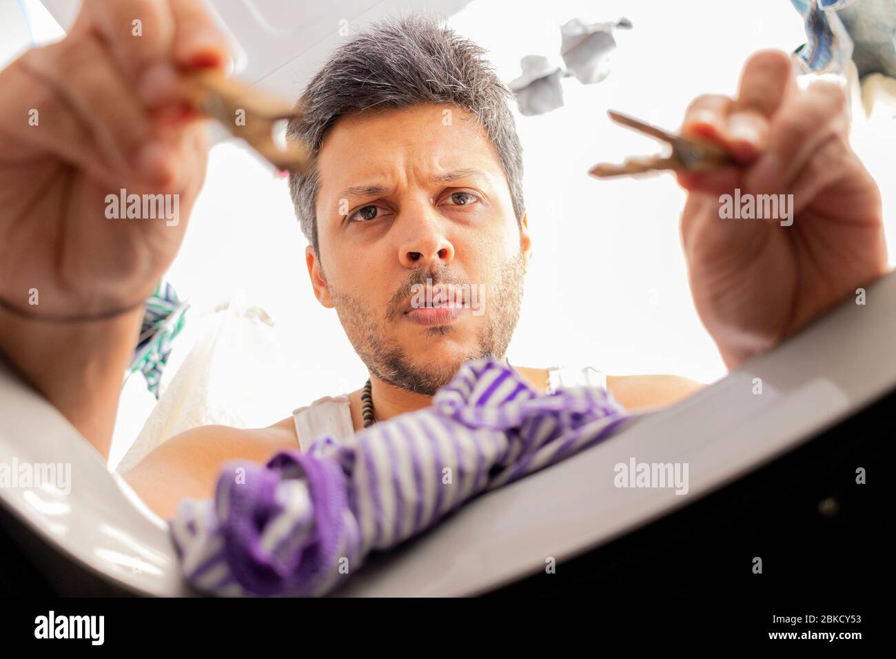 Bearded man using washing machine at home Stock Photo