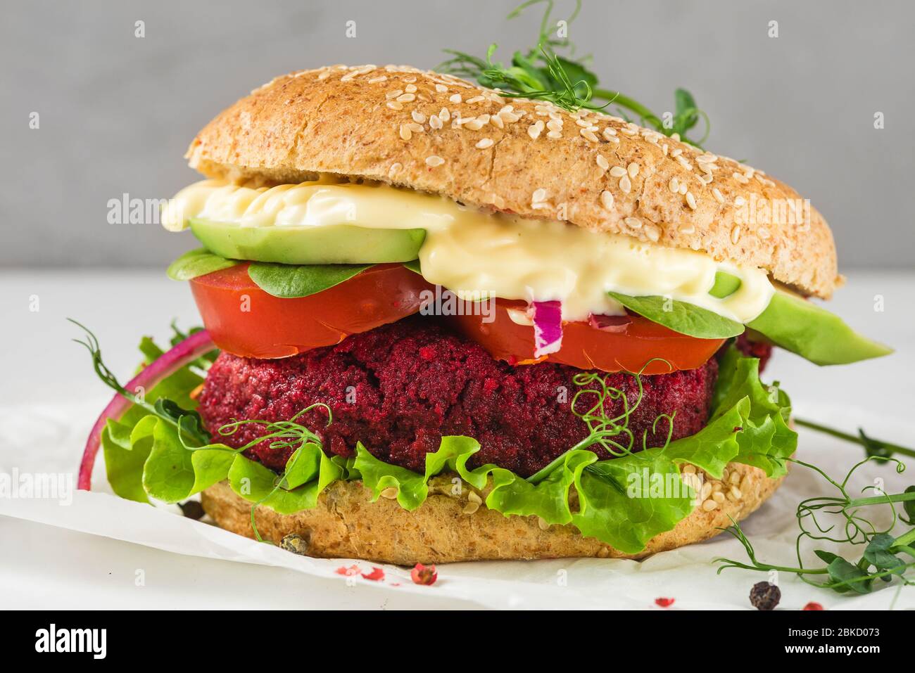 Veggie burger with beetroot and avocado on white marble table. Healthy vegan food. close up Stock Photo