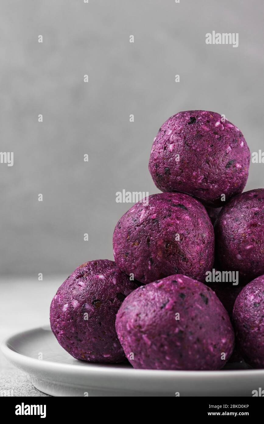 Energy balls made of blueberries, acai, dates and nuts. Healthy vegan food dessert. vertical orientation. close up Stock Photo