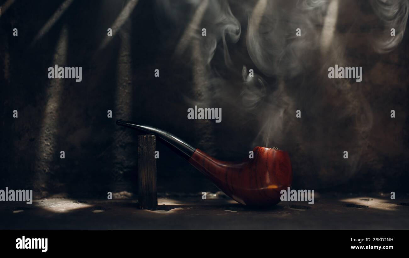 Smoking pipe cherry tree material on steel background with tobacco