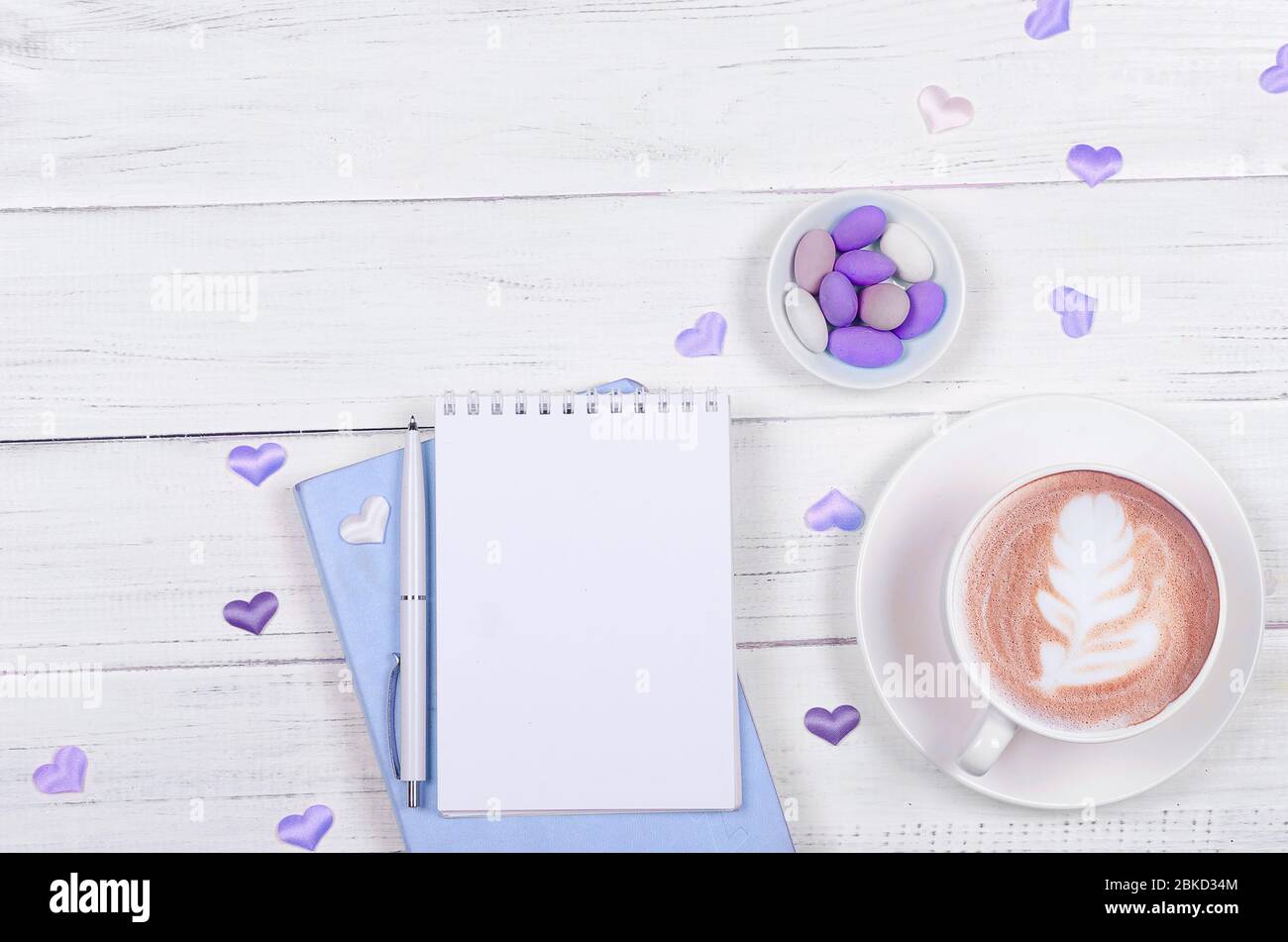 Creative flat lay of workspace desk, notepad for wishlist and coffee cup on wooden background Stock Photo