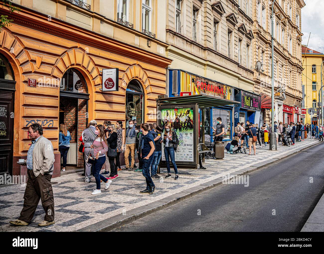People in face masks are waiting in a long cue in front of a newly opened Italian ice-cream bistro Creme de la Creme in centre of Prague, on Friday, M Stock Photo