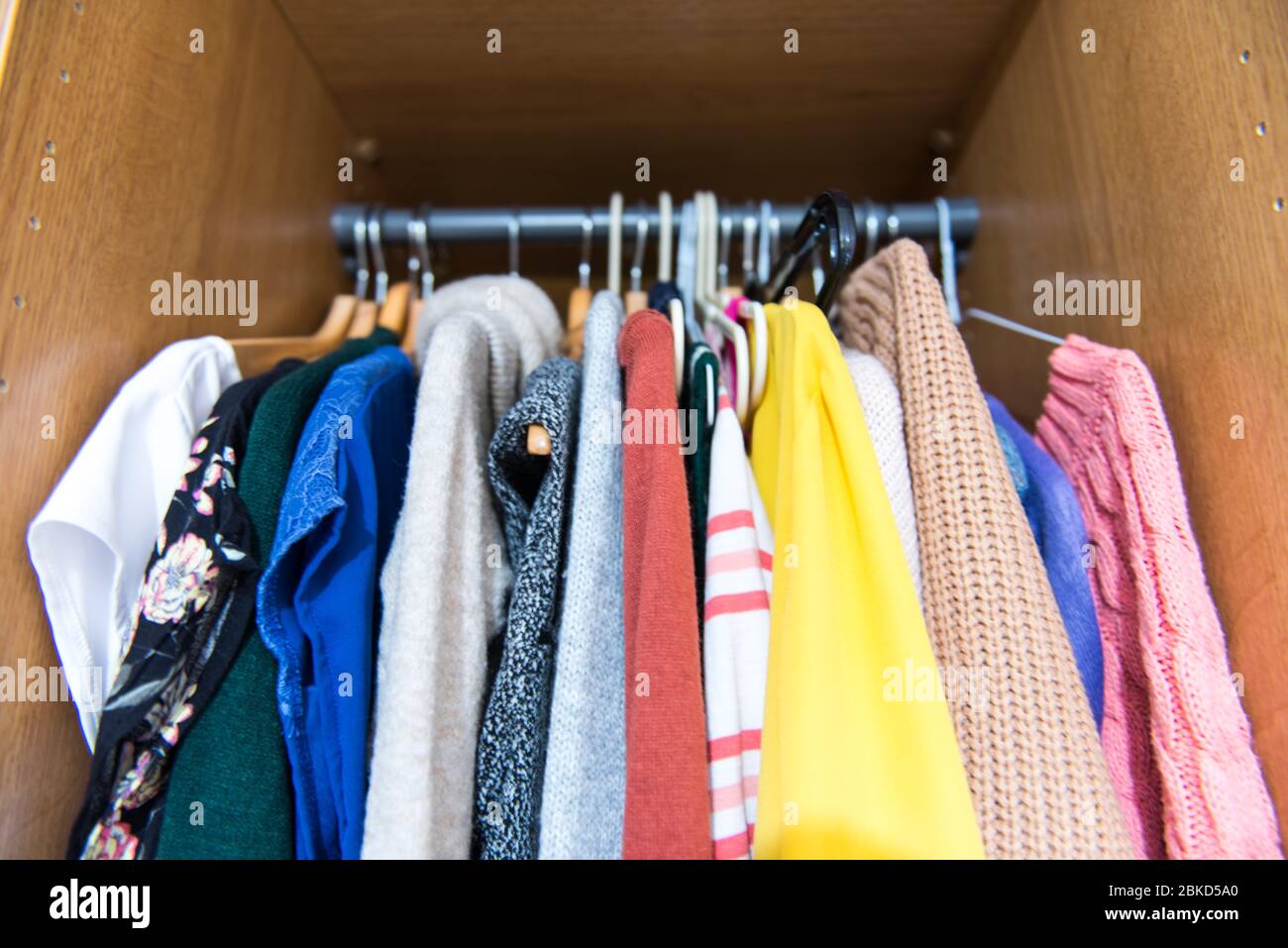 Unorganised clothes in a Womans wardrobe Stock Photo