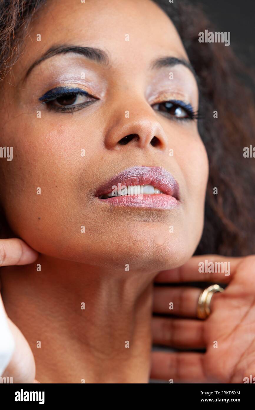 Young woman relaxing stretching her neck with her hands behind her head as she de-stresses after a stressful day in a close up cropped head shot portr Stock Photo