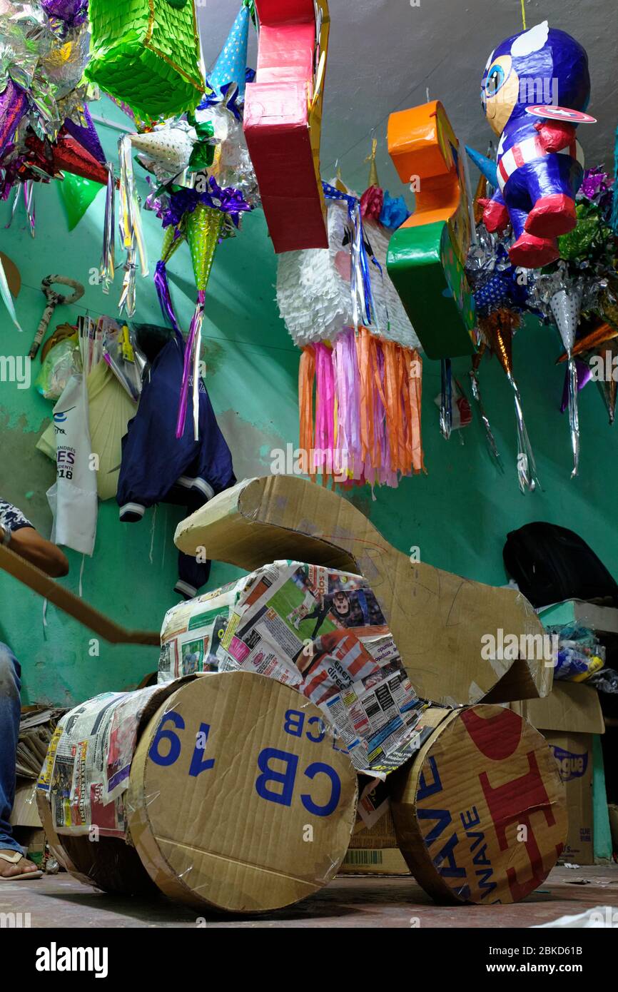 Craftsman making piñatas with newspaper and cardboard in his small workshop in the city of Valladolid. Piñatas are figures made of paper, cardboard an Stock Photo