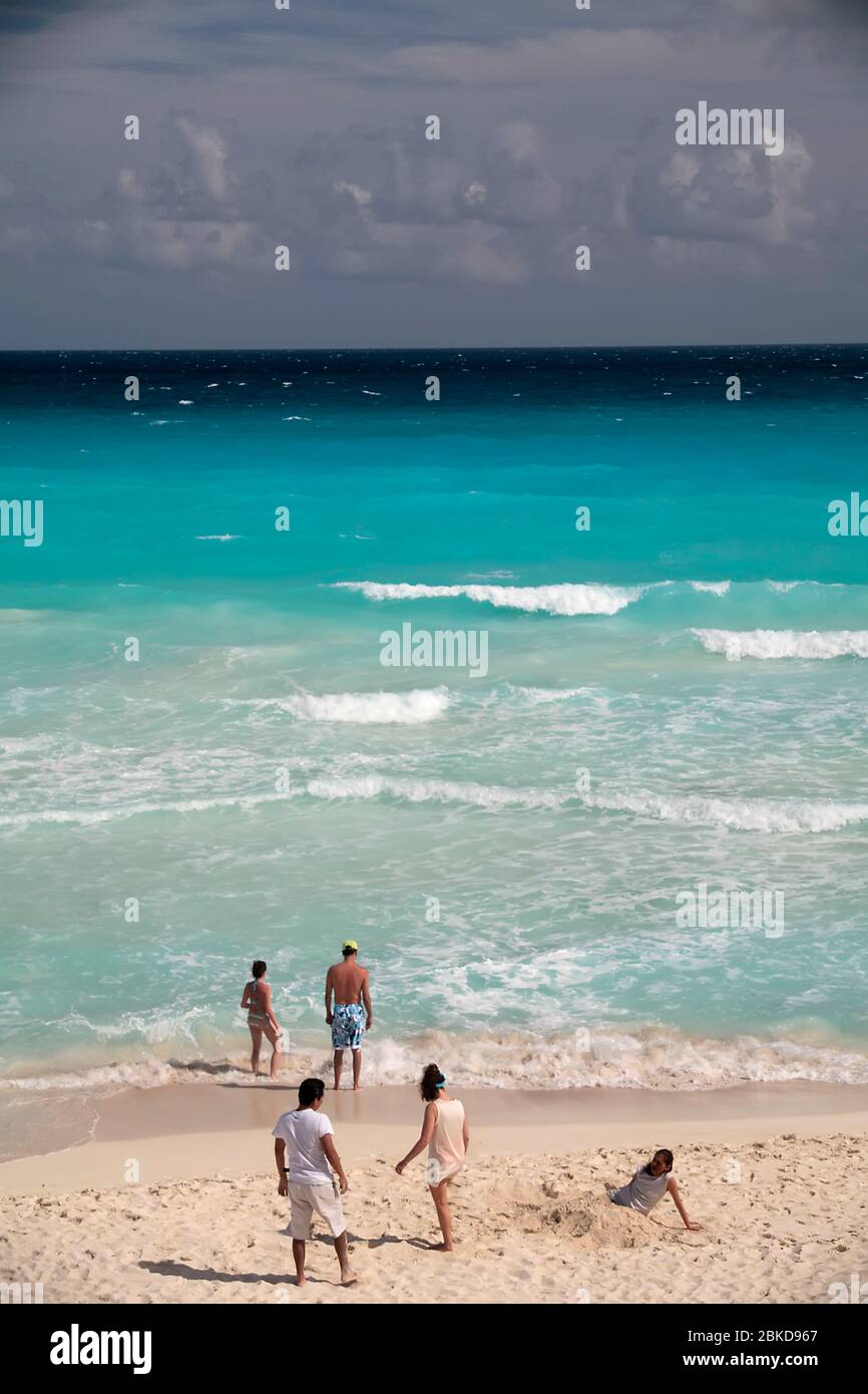 People on beach with turquoise sea Stock Photo