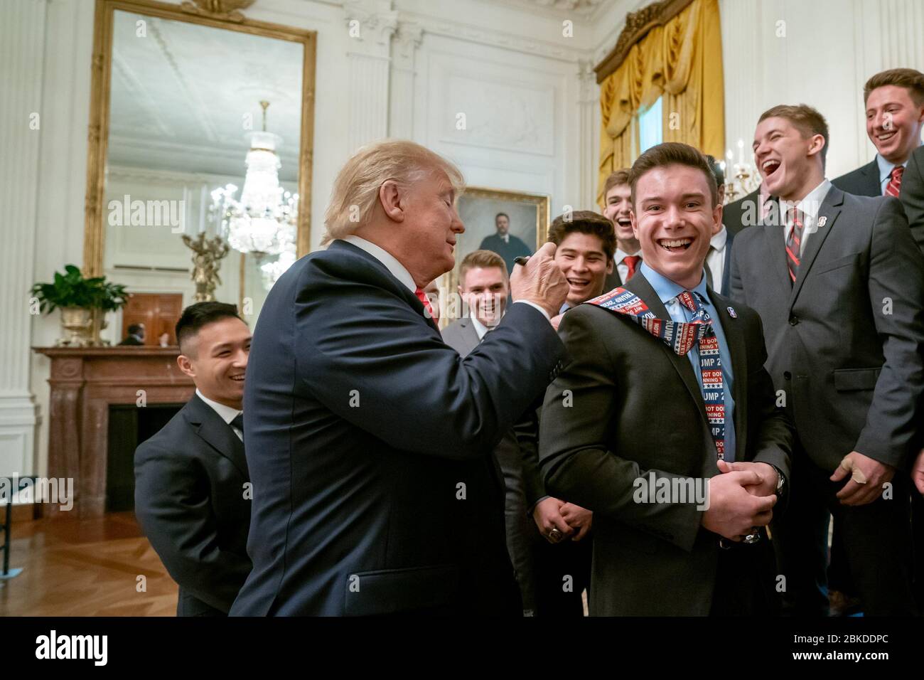 President Donald J. Trump signs the tie of one of the members of the 2019 NCAA Stanford University Men’s Champion Gymnastics team Friday, Nov. 22, 2019, during the NCAA Collegiate National Champions Day in the Blue Room of the White House. President Trump Greets NCAA National Champions Stock Photo