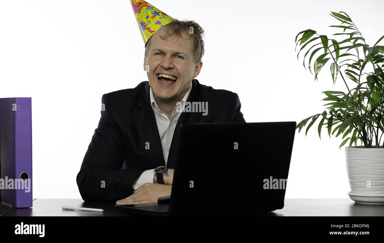 Drank sleepy young clerk man sitting at the office desk with a hangover