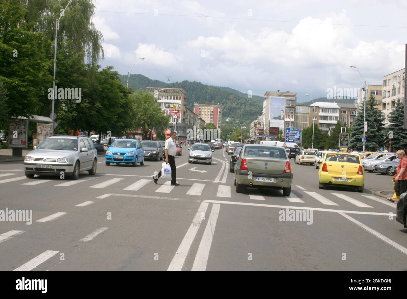 Driving through Baia Mare, Romania. People crossing the street through traffic. Stock Photo