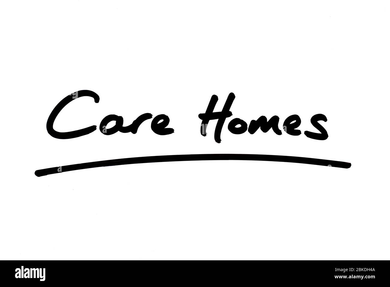Care Homes handwritten on a white background. Stock Photo