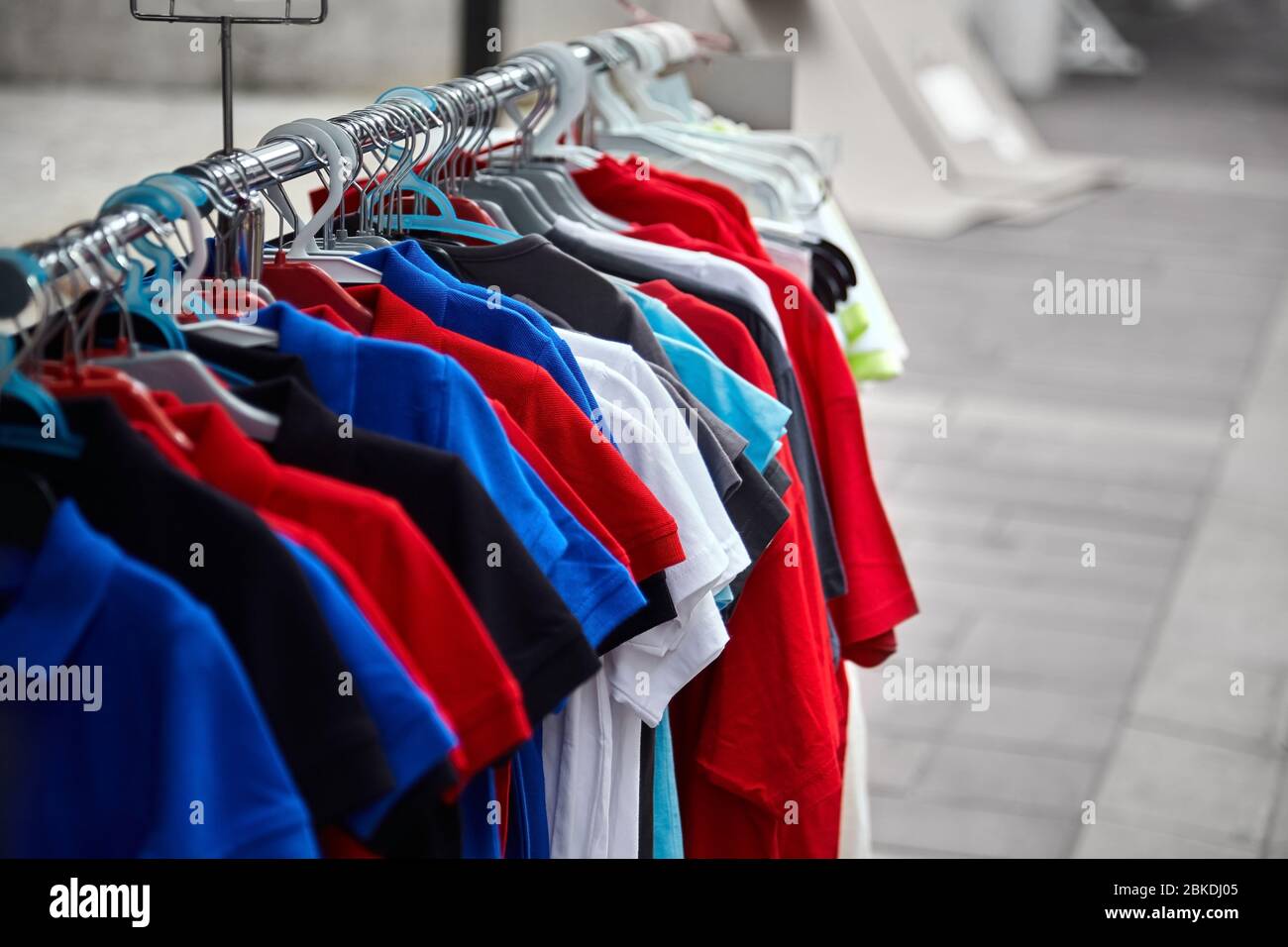Colorful polo t-shirts for the man on hangers in a store. Street sale of  male clothes Stock Photo - Alamy