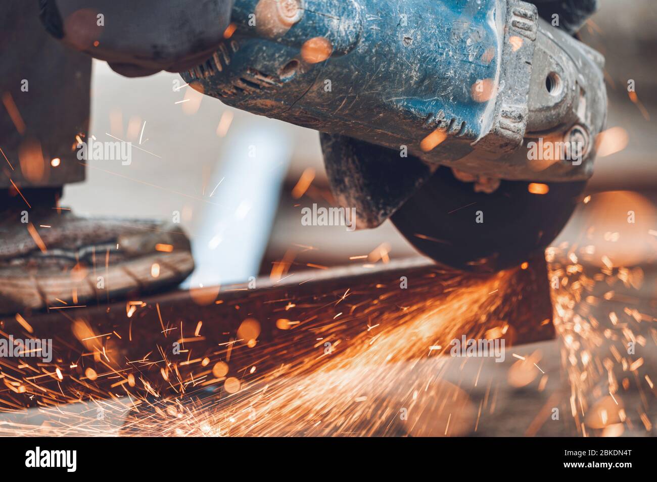 Construction worker using Angle Grinder cutting Metal at construction site . Stock Photo