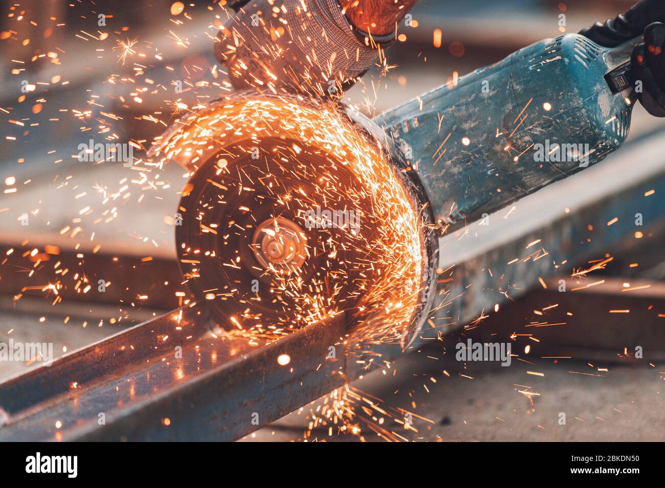 Construction worker using Angle Grinder cutting Metal at construction site . Stock Photo