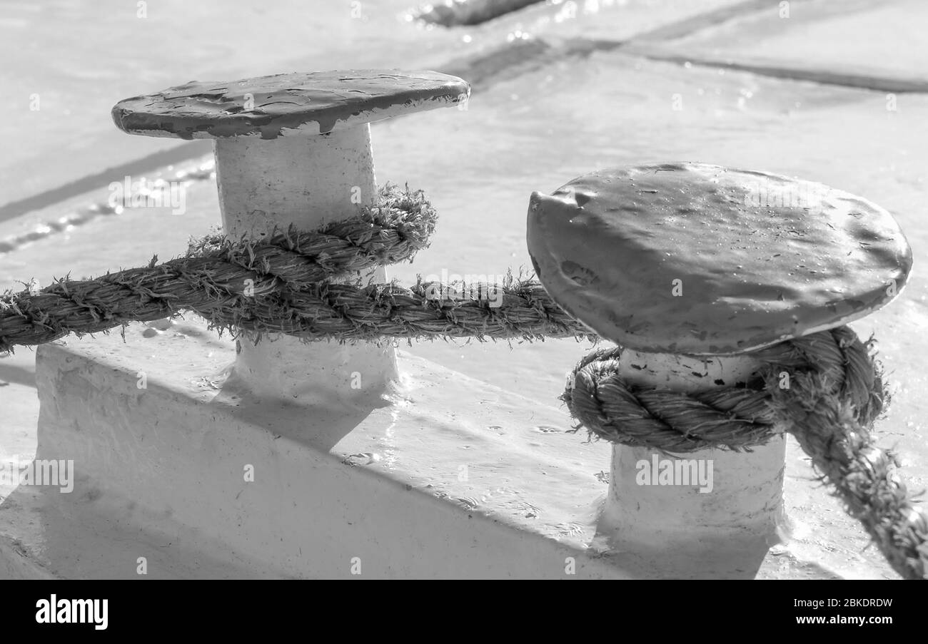 Two large cleats on a dock with a large rope for docking a large ship